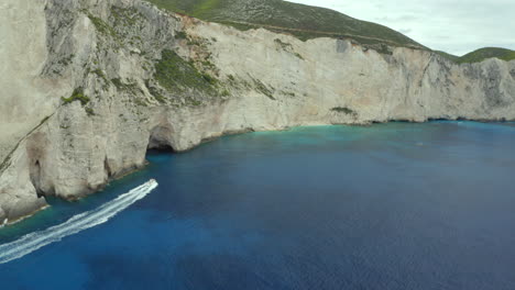 aerial drone shot of fast moving boat on a boat your near shipwreck beach in zakynthos, greece