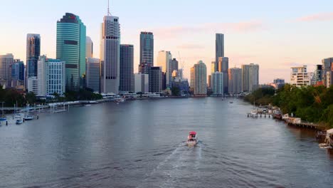 Lancha-Navegando-En-El-Río-Brisbane-Con-Vistas-A-Los-Edificios-De-Gran-Altura-En-Brisbane-Cbd-Al-Atardecer-En-Qld,-Australia