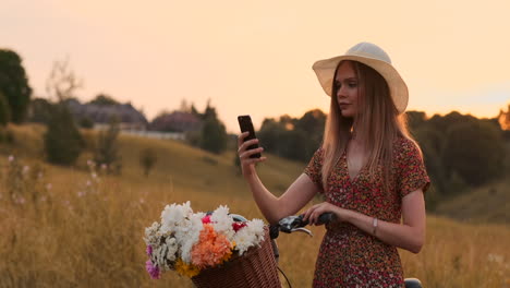 Verano-Joven-Hermosa-Chica-De-Pie-Con-Bicicleta-Fotografiada-Tomando-Selfie-En-Su-Teléfono-Móvil.