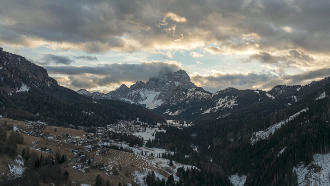 Aerial hyperlapse timelapse of Dolomites Mountains in winter season. Moving clouds at sunrise