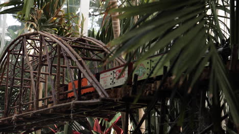 model train on a wooden bridge in a greenhouse