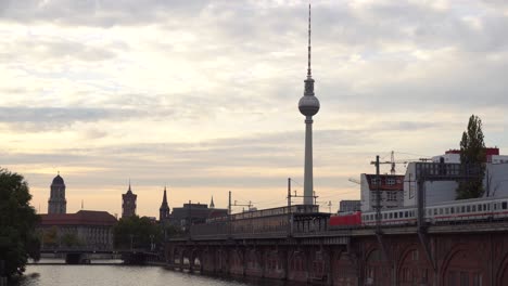 puesta de sol de la ciudad de berlín en el puente junto al río spree y la estación de tren