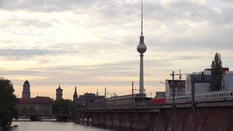 sunset of berlin city on bridge next to river spree and railway station