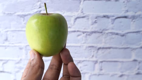 a green apple held in hand