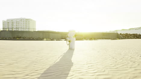 sunlight filtering through a coastal landscape with sand and buildings in view