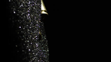 vertical macro shot of 6mm arc bullets falling on gunpowder, black background