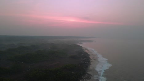 Red-sunrise-over-foggy-sea-coastline,-aerial-view