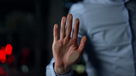 macro de la mano del hombre en la pared de vidrio en el interior. hombre desconocido sosteniendo la palma.