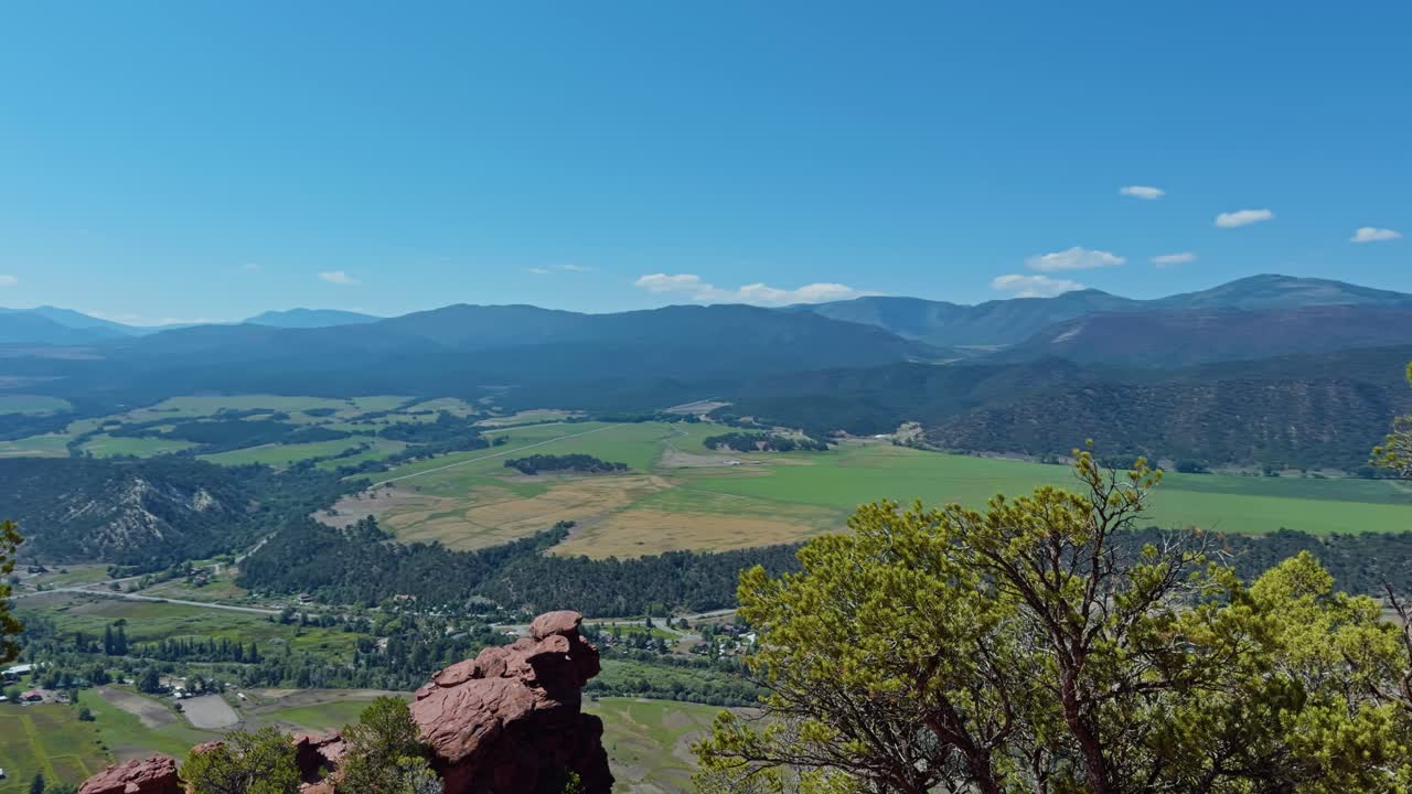 Bright sunlit valley with expansive mountain view and grassy terrain, early morning glow, Red Hill Carbondale Colorado USA