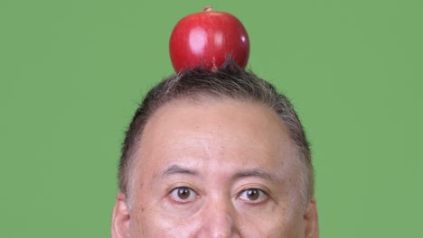 mature japanese businessman with apple on head