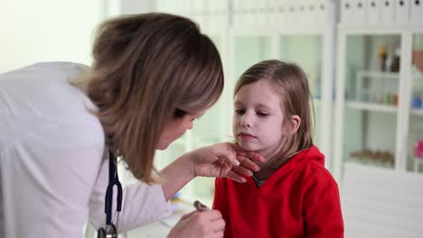 doctor examining a young child's throat during a medical check-up