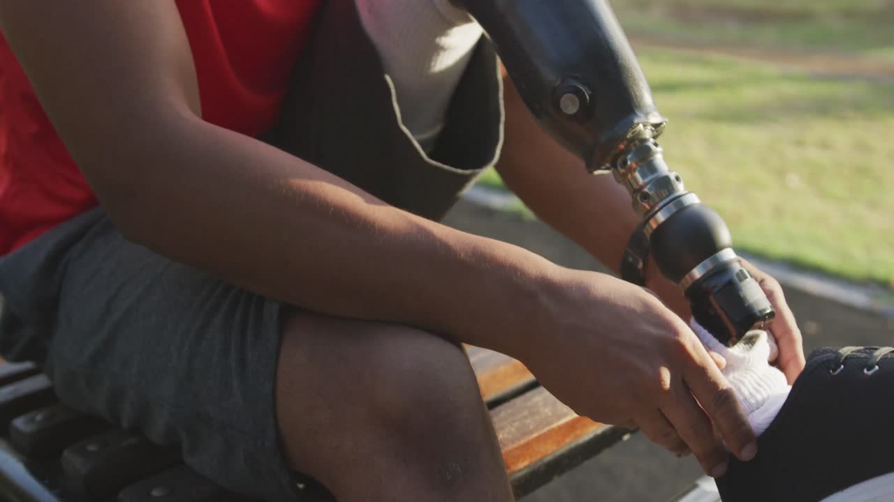 Front view man with prosthetic leg tying his shoelaces