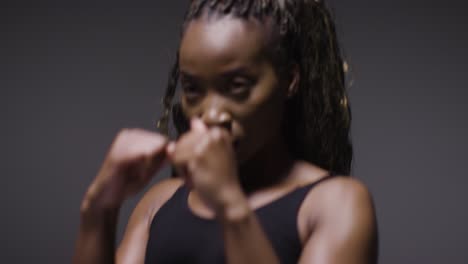 studio portrait of young woman wearing gym fitness clothing training for boxing exercise