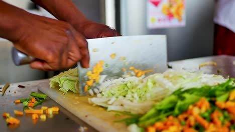 un chef cortando verduras con un cuchillo de cuchilla en una tabla de cortar blanca a cámara lenta, tiro estático