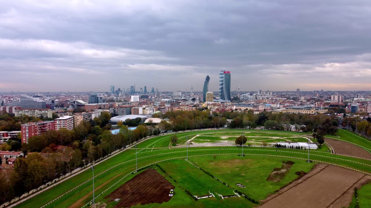 Aerial drone view of Milan skyline from the racetrack, showing urban buildings, skyscrapers, and the full cityscape