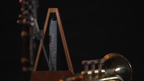 static shot of an analog metronome, against a dark background