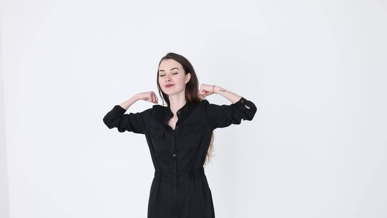 Woman in black jumpsuit posing in studio