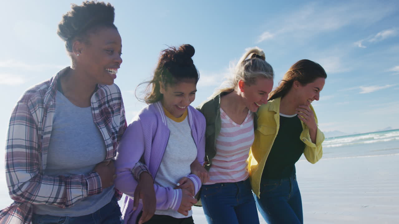 다양한 여성 친구 들 의 행복 한 그룹 이 해변 을 따라  ⁇ 고 즐겁게 지내고 있다