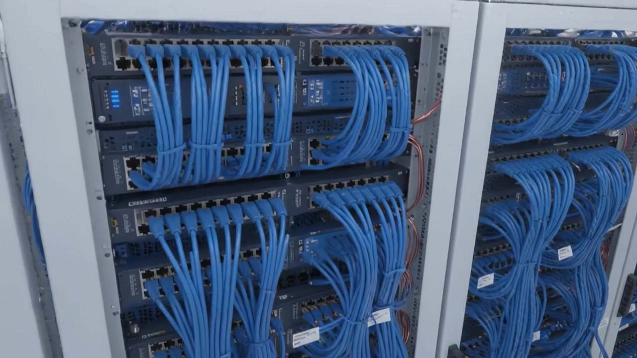 Interior View of a Data Center Showing Organized Server Racks with Blue Cables Interconnected for Efficient Networking Solutions and Data Management