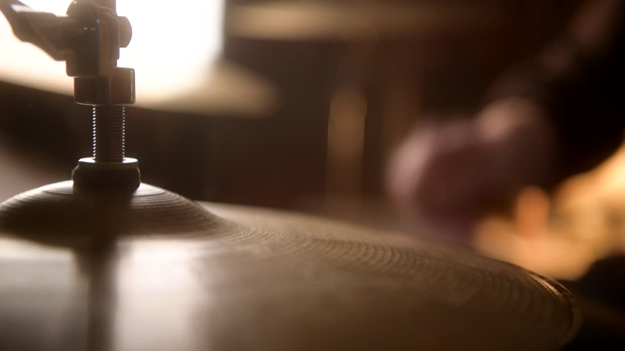 Primo piano di un batterista che suona sui piatti charleston della batteria durante una sessione in studio di registrazione
