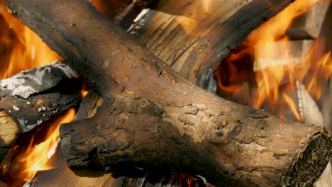 a log of wood on fire. close-up background beautiful flame of fire on wood. slowly burn the chopped wood in the stone fireplace with an orange flame.