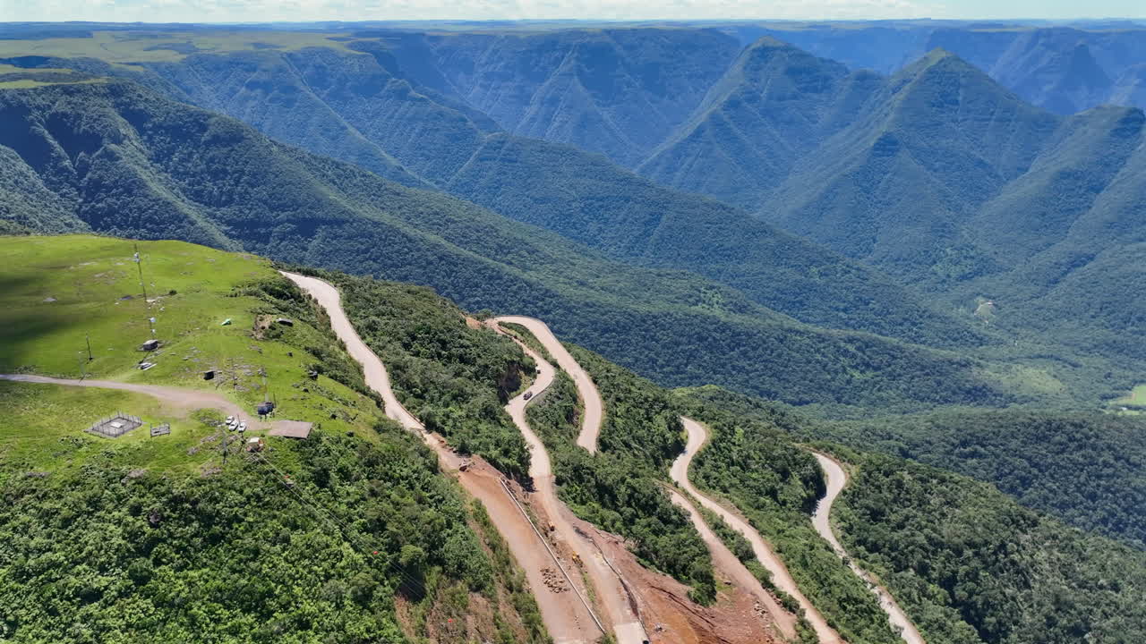 Vista aerea di una strada di montagna con lavori di costruzione finali visibili sui pendii ripidi nella Serra da Rocinha, Brasile.