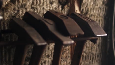 Hammer-and-blacksmith-tools-hanging-on-the-shelf-in-an-artisan's-workshop