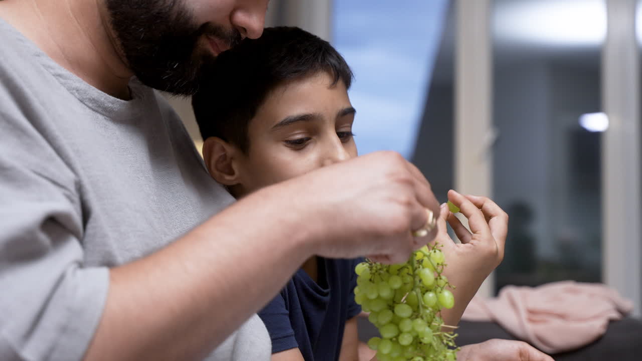 소파 에 앉아 있는 작은 소년과 아버지 의 근접적 인 모습