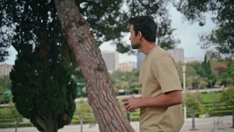 carefree guy strolling nature park holding coffee cup closeup. italian man enjoy