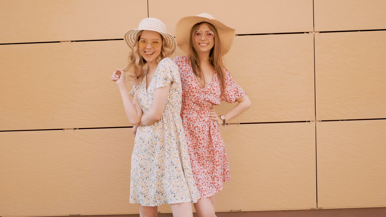 dos mujeres con vestidos florales y sombreros
