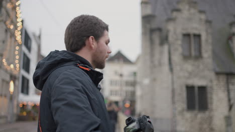 young caucasian man taking photos of urban landscape while in europe