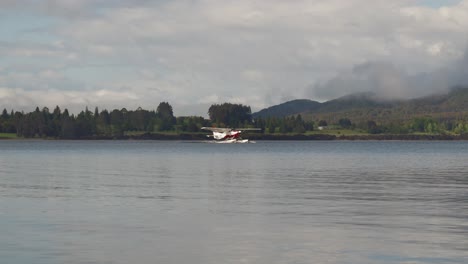 distant floatplane traveling on smooth calm lake, new zealand