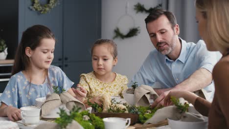 caucasian family of five spending time over table on easter time.