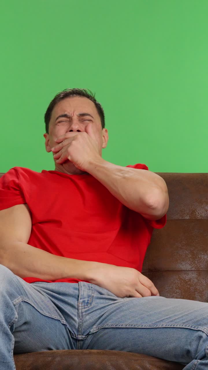 Man gets bored watching tv and starts using his phone