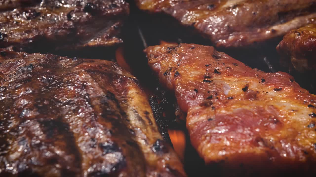 Costillas sabrosas cocinándose en la parrilla para una fiesta de verano al aire libre
