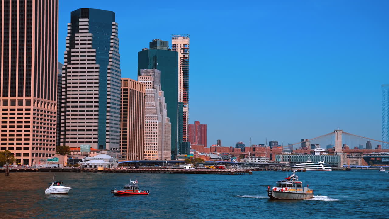 New York, Hoa Kỳ, ngày 9 tháng 8 năm 2025: Hạ Manhattan cạnh bờ sông ở Thành phố New York. Thuyền bè đi ngang qua đường chân trời của Khu Tài chính dọc theo bờ sông Hạ Manhattan