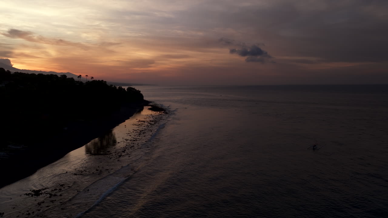 Paesaggio costiero tranquillo, cielo al tramonto scuro e colorato, Oceano Indiano