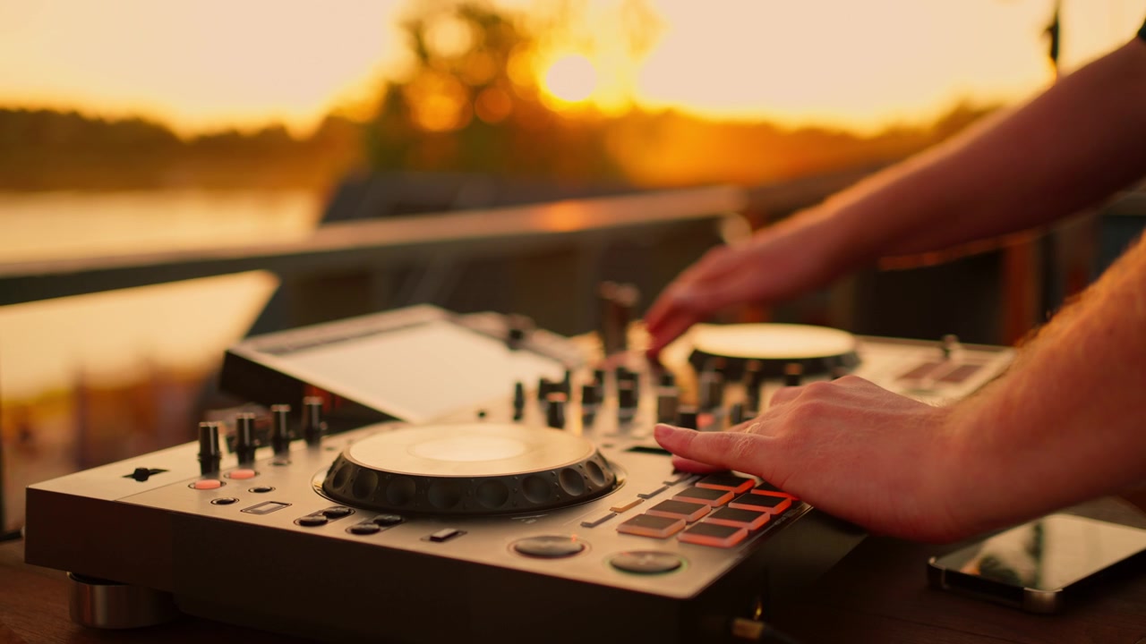 DJ che mixa musica su console al tramonto