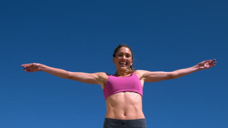 Fit-blonde-smiling-and-jumping-up-on-sunny-day