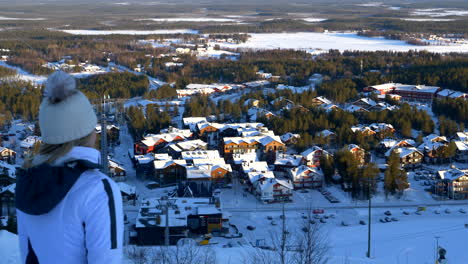 woman on ski holiday overlooking resort town, levi, finland