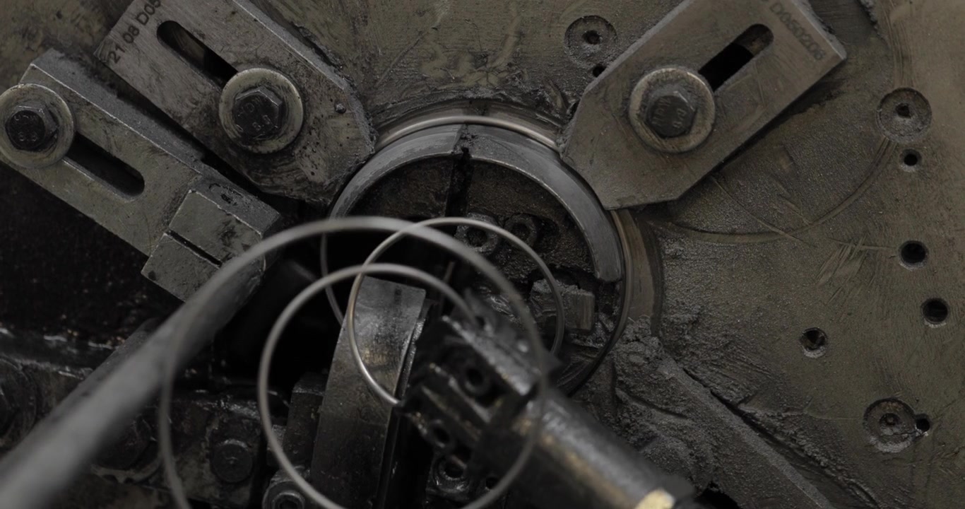 Extrémní detail pracujícího stroje na výrobu pružin, 4K.