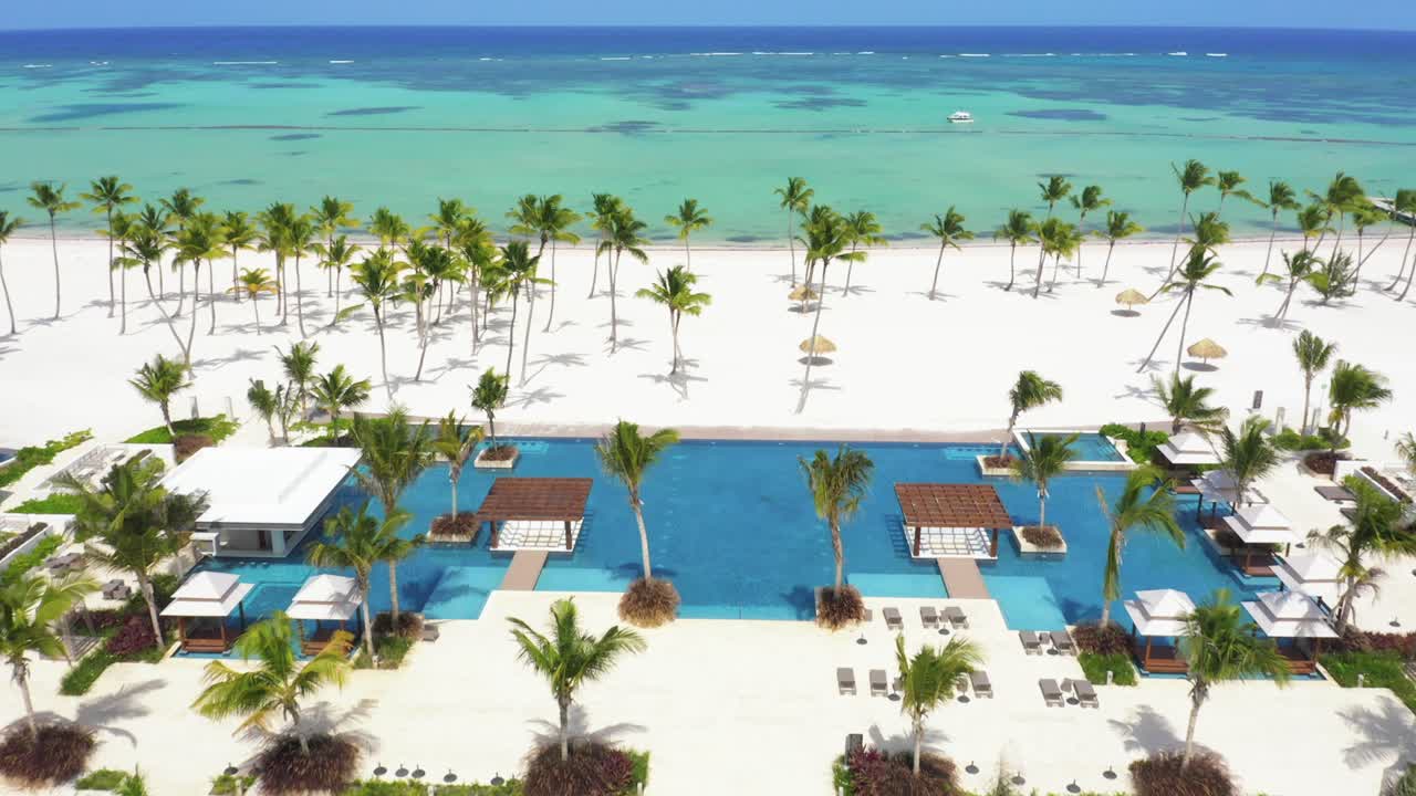 vuelo de drones entre la piscina del hyatt ziva cap cana con vistas a las aguas azul turquesa de la playa de juanillo