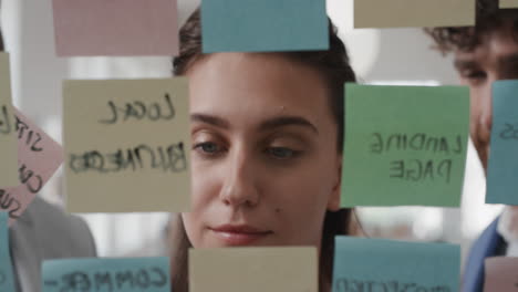 business woman using sticky notes  brainstorming ideas with colleagues problem solving using creative mind map planning strategy in office working on solution