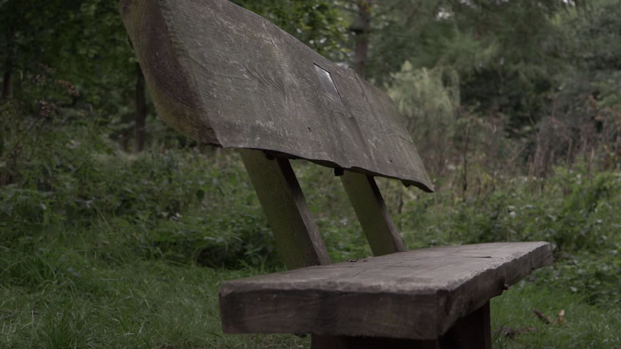 Rustic wooden bench in countryside close up tilting shot