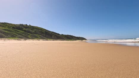 footprints on sandy beach with ocean waves