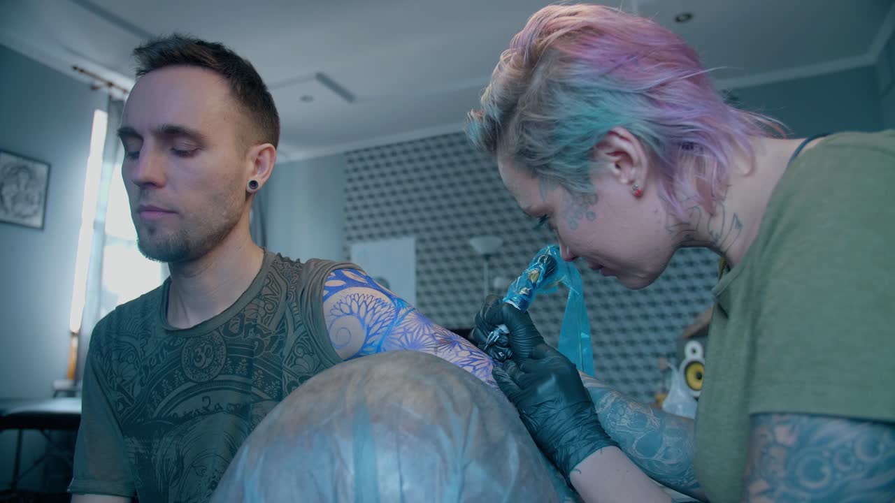 Tattoo Artist Working on a Client's Arm