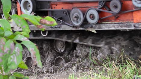 combine harvester on a muddy paddy field, cogwheels and belts running and stop machine motor slow motion close up b roll clip