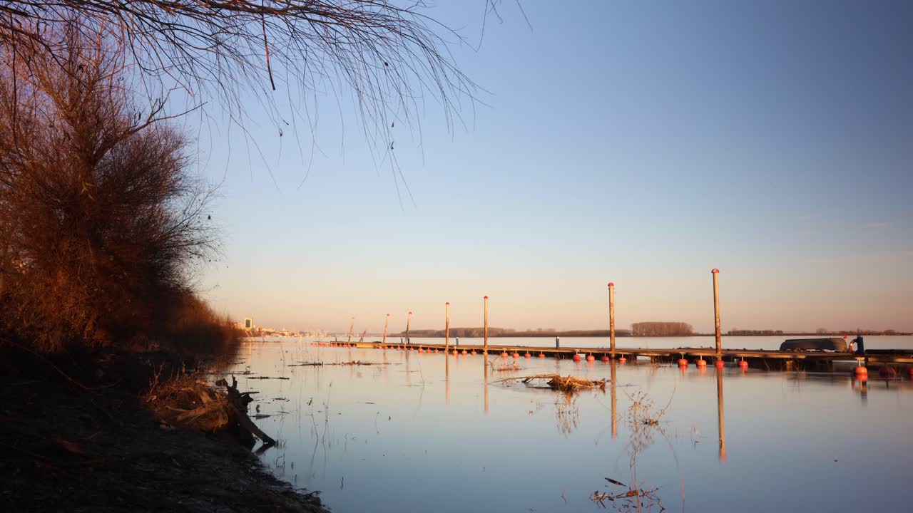 루마니아 갈라티 시 근처 일몰 동안 다뉴브 강에 있는 나무 판자길