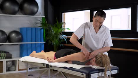 terapeuta femenina masajeando los hombros del paciente