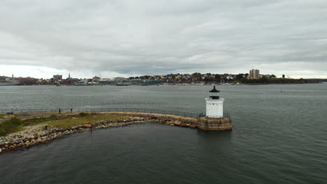 wide drone shot of a bug lighthouse off the coast of portland, maine